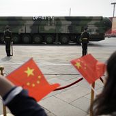 Spectators wave Chinese flags as military vehicles carrying DF-41 nuclear ballistic missiles roll during a parade to commemorate the 70th anniversary of the founding of Communist China in Beijing on Oct. 1, 2019. (AP Photo/Mark Schiefelbein, File)