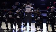 Orlando Magic&#x27;s Jonathan Isaac (1) stands as others kneel before the start of an NBA basketball game between the Brooklyn Nets and the Orlando Magic Friday, July 31, 2020, in Lake Buena Vista, Fla. (AP Photo/Ashley Landis, Pool)